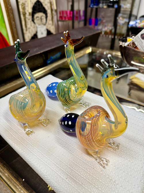 Ripkitty 5" peacock art borosilicate glass hand pipe — yellow-amber body with teal stripe detailing, sculpted peacock neck and beak mouthpiece, blue polka-dot bowl, white background