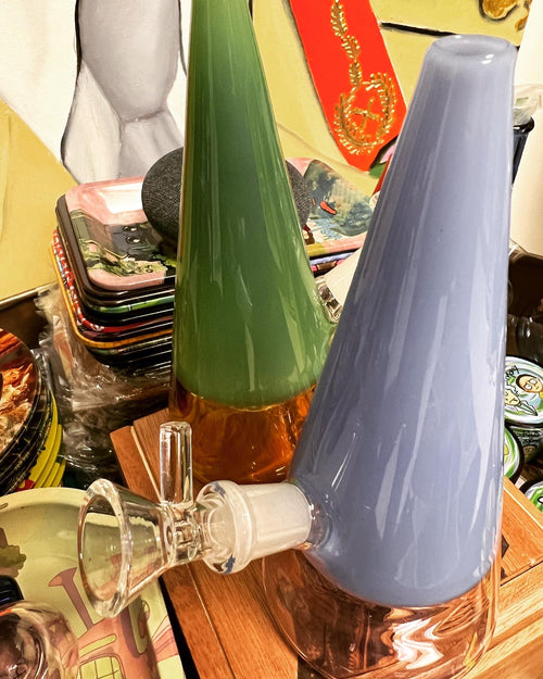 Two Ripkitty 7" cone showerhead water pipes — forest green with amber base and slate blue — showing clear glass downstem and bowl joint detail