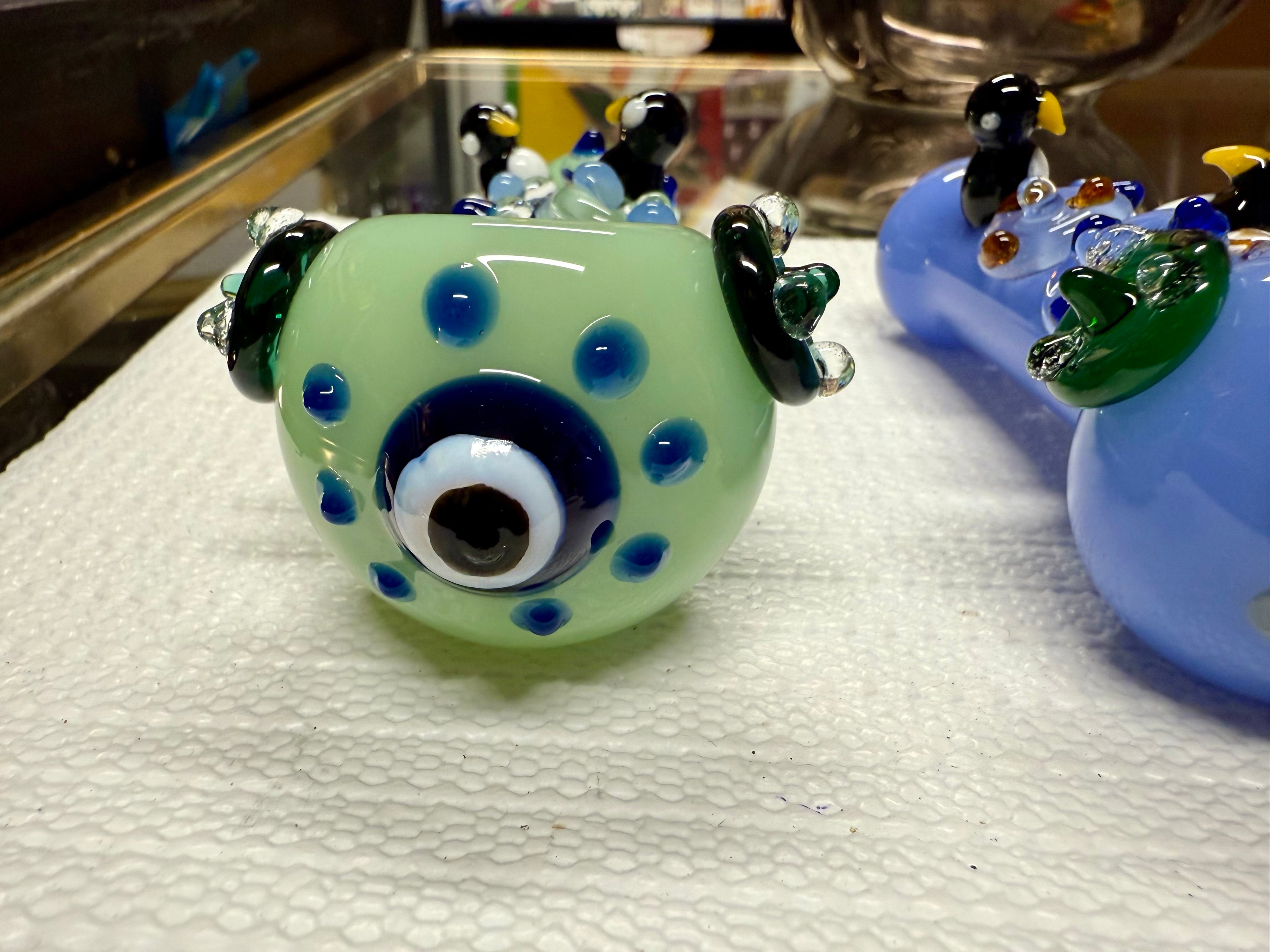 Ripkitty penguin art pipe — mint green colorway, three-quarter angle showing penguin sculpts, dot pattern, and mouthpiece