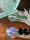 Bowl-end detail of Ripkitty 4" silver fumed frit hand pipes — iridescent purple-tinted bowl on one pipe, green marble accents on the other, frit texture visible