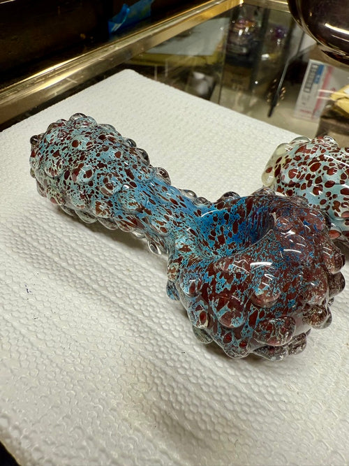 Ripkitty 5" blue spike spoon pipe — teal-blue and dark red frit with raised bubble spike texture, angled side view showing full pipe profile on white background