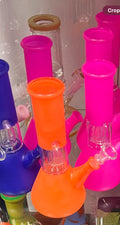 Assorted vivid-color 8-inch dome glass water pipes in neon orange, hot pink, and blue colorways displayed together — Ripkitty x Bud's Growery