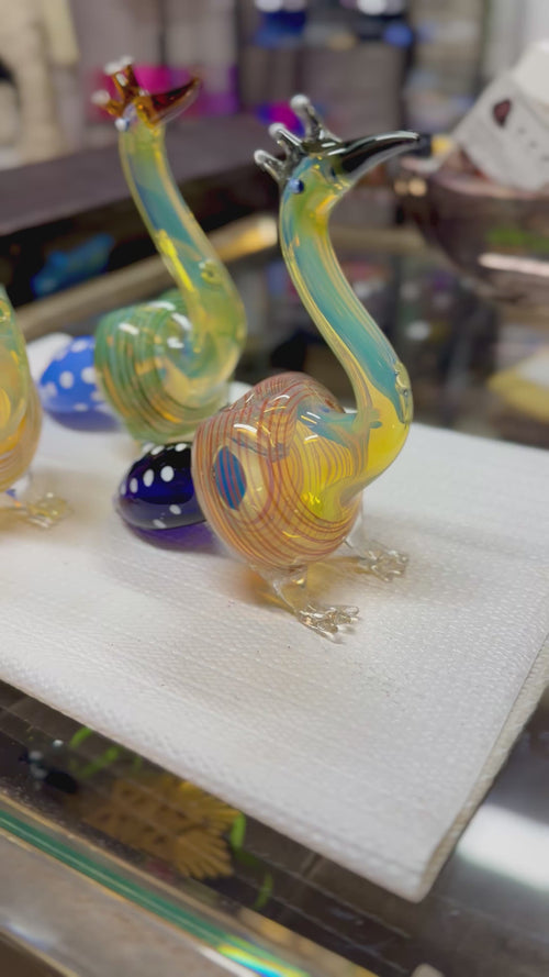 Ripkitty 5" peacock art borosilicate glass hand pipe — 360° display video showing sculpted peacock form, teal and amber-red colorways, crest prong mouthpiece, glass eye bead, and blue polka-dot bowl